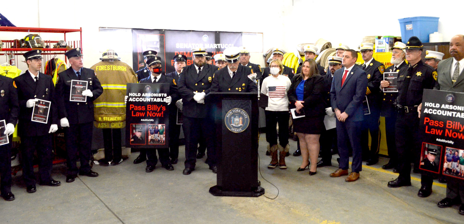 Jim Steinberg, at podium, speaking at the announcement of 'Billy's Law', legislation in honor of his son's death, flanked by legislators, law enforcement officials and fire service members.